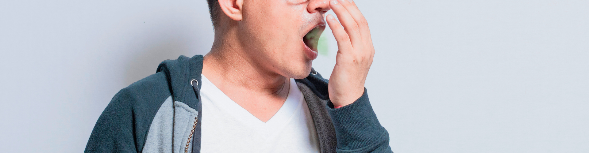 Man blowing green breath into his hand.